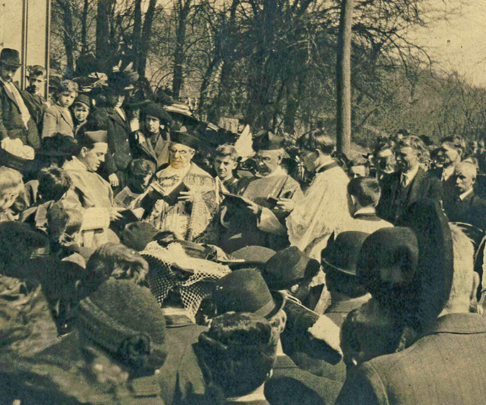 The blessing of the new church bell at the former St. Michael Church in Madison is shown in this photo from March 19, 1911. The bell is wrapped in a white net. The pastor, with his back to the church wall, is Father Joseph Bauer. The other two priests to his right are Father George Widerin and Father Michael Guthneck. St. Michael Parish merged with other Madison area parishes to form Prince of Peace Parish in 1993. St. Michael Church is now operated as a historic landmark.