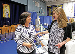 Mother and daughter Teresa, left, and Brigette Schutzman, members of St. Luke the Evangelist Parish in Indianapolis, greet each other in the parish&rsquo;s school gymnasium during a Mary&rsquo;s WAY event on Oct. 24. (Submitted photo by Victoria Arthur)