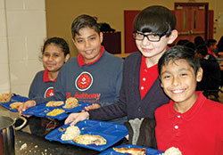 Sixth-graders Yasmin Carlos, left, Miguel Macias,&nbsp;Jonathan Villegas and David Anzurez line up for lunch at St. Anthony School in Indianapolis. (Photo by John Shaughnessy)