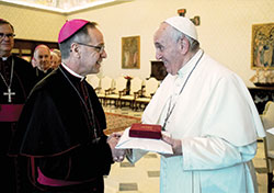 Pope Francis presents Archbishop Charles C. Thompson with a gift on Dec. 12 after the pontiff met in the Apostolic Palace at the Vatican with bishops from Illinois, Indiana and Wisconsin as part of their &ldquo;ad limina&rdquo; visit, a pilgrimage to Rome that all bishops from around the world are required to make every five to seven years. (Vatican Media)