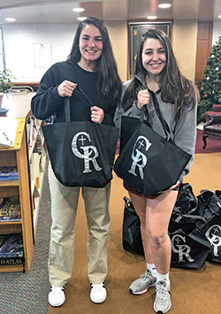 Gabriella Hicks, left, and Chloe Olejnik, both seniors at Cardinal Ritter Jr./Sr. High School in Indianapolis, hold bags that they and fellow students filled with food for students in need in Catholic schools in the Indianapolis West Deanery. The student-driven &ldquo;Backpack Blessings&rdquo; program is in its second year and provides food for 150 students in the West Deanery during three breaks in the academic year. (Submitted photo)