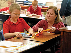 Amy Kersey helps second-grader Jackson Boggs on Jan. 9 at St. Michael School in Brookville. Kersey is the school&rsquo;s second-grade teacher. (Photo by Sean Gallagher)