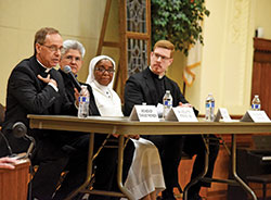 Archbishop Charles C. Thompson, left, Benedictine Sister Nicolette Etienne, Daughters of Mary Mother of Mercy Sister Loretto Emenogu and Father Jeffrey Dufresne take part in a Jan. 29 panel discussion on priestly and religious vocations at the Archbishop Edward T. O&rsquo;Meara Catholic Center in Indianapolis. It was attended by approximately 100 students from Catholic schools across central and southern Indiana. (Photo by Sean Gallagher)