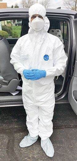 Father Sengole Thomas Gnanaraj, administrator of St. Elizabeth Ann Seton Parish in Richmond, wears a protective suit outside a home in Connersville before going in to anoint three family members&mdash;two who had tested positive for the coronavirus, including one who was believed to be close to death, and a third who was presumed to have been infected by the virus. (Submitted photo)