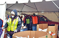 Volunteers place food in the trunk of a car on March 28 as part of the temporary drive-through process the Indianapolis Society of St. Vincent de Paul&rsquo;s leadership devised for its Food Pantry to adapt to guidelines during the COVID-19 outbreak. (Submitted photo by SunShine Rucker)