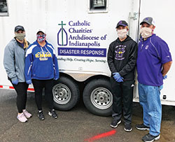Peyton Levine, left, Michelle Neibert-Levine, and Andrew and Matt Levine, members of St. Ambrose Parish in Seymour, pose on April 23 beside a food truck donated by the archdiocesan Catholic Charities Disaster Response office to help feed the growing number of hungry families and individuals through Waymaker Ministries&rsquo; &ldquo;Feed Seymour&rdquo; effort. Neibert-Levine is principal of St. Ambrose School. (Submitted photo)