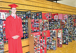 Michael Mark, a graduating senior of Cardinal Ritter Jr./Sr. High School in Indianapolis, poses on May 27 with his classmates, figuratively speaking, in the form of story boards each senior&rsquo;s family made for their graduation ceremony. (Photo by Natalie Hoefer)