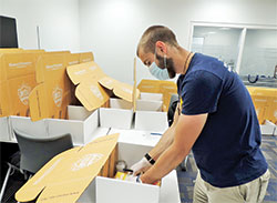 Marian University mentor Joel Kelley double checks the contents of a Missionary Discipleship Institute participant&rsquo;s box before it is sealed. (Submitted photo)