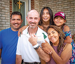 Father Christopher Wadelton poses for a photo with the family of Rebeca Barcenas, the woman he donated a kidney to on May 14. The family members are Rebeca&rsquo;s husband, Rafael Ventura, left, and their two daughters, Jennifer and Carmen. (Photo by D. Todd Moore)