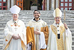 Benedictine Father Lorenzo Penalosa, center, a monk of Saint Meinrad Archabbey in St. Meinrad, poses on Aug. 30 outside the monastery’s Archabbey Church of Our Lady of Einsiedeln after being ordained a priest. He poses with Benedictine Archabbot Kurt Staskiak, left, and Archbishop Charles C. Thompson, who ordained him. (Photo courtesy of Saint Meinrad Archabbey)