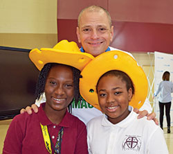 Stephen Ritz has created a school program that uses urban agriculture to improve students&rsquo; lives and the communities where they live. During a visit to Holy Angels School in Indianapolis, he poses with students Ashley Houessinon, left, and Atavia Boyle. (Submitted photo)