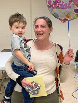 Kristina Seipel gets a hug and a balloon from her 2-year-old son Michael after she received the archdiocese&rsquo;s Excellence in Catechesis Award which has been re-named in honor of the late Archbishop Daniel M. Buechlein. (Submitted photo)