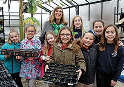 Members of the horticulture club at St. Bartholomew School in Columbus pose for a photo with principal Helen Heckman in the school&rsquo;s greenhouse-outdoor learning lab in March. (File photo by John Shaughnessy)