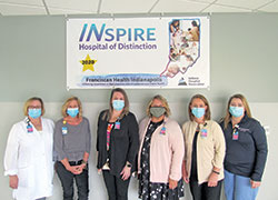 Angela Bratina, third from right, administrative director of Franciscan Health Indianapolis&rsquo; Center for Women & Children, poses with nurses Christine Hunkele, left, Erin Neu, Melanie Boosey, Jennifer Naessens and Stephanie Lee in front of a banner noting the recognition they helped earn for Franciscan Health from the Indiana Hospital Association as an INspire Hospital of Distinction in the area of care for mothers and babies. (Submitted photo)