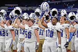 Bishop Chatard football players raise their helmets in celebration after the archdiocesan Indianapolis North Deanery high school won the Class 3A Indiana High School Athletic Association championship at Lucas Oil Stadium on Nov. 28. (Submitted photo by Mia Todd)