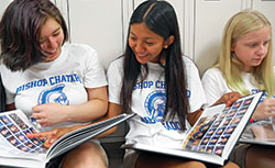 Bishop Chatard High School student Deysi Garcia-Vazquez, center, enjoys checking out the Indianapolis North Deanery high school&rsquo;s new yearbook at the beginning of the 2019-20 academic year with fellow Trojans Emma Shea, left, and Gracie Dillon. (Submitted photo)