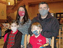 Megan and Mike Smith brought their family to the Catholic Schools Week Mass at SS. Peter and Paul Cathedral in Indianapolis on Feb. 3. Here, the couple kneels behind Adele and Alex&mdash;two of their four children who all attend St. Lawrence School in Indianapolis. Their two older children, Zach and Justin, were seated nearby. (Photo by John Shaughnessy)