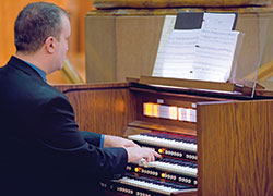 Andrew Motyka, director of archdiocesan and cathedral liturgical music, plays the organ for his sister-in-law&rsquo;s wedding Mass at St. Mary Church in Indianapolis in October 2019. (Photo credit: Amy Counts Photography)