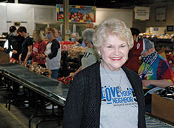 Throughout the pandemic, Darlene Sweeney has felt her prayers have been answered in her role as director of volunteer services for the Indianapolis Council of the Society of St. Vincent de Paul. In this March 24 photo, she poses at the society&rsquo;s food pantry in Indianapolis as volunteers from St. Mark the Evangelist Parish in Indianapolis put together boxes of food for home deliveries to people in need. (Photo by John Shaughnessy) 