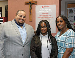 Jeff Crittendon, Braelynn Crittendon and Tiffany Underwood pose for a family photo at Holy Angels School in Indianapolis, where Braelynn is attending school with the help of Indiana&rsquo;s Choice Scholarship Program, more commonly known as the voucher program. (Photo by John Shaughnessy)