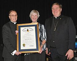 Archbishop Charles C. Thompson and Cardinal Joseph W. Tobin of Newark, N.J. (formerly the archbishop of Indianapolis) share smiles with archdiocesan chancellor Annette &ldquo;Mickey&rdquo; Lentz as she holds the Sagamore of the Wabash, the state of Indiana&rsquo;s highest honor, during the archdiocese&rsquo;s inaugural Legacy Gala, held in person at the JW Marriott in Indianapolis and via livestream on April 16. The two archbishops and Lentz have each received full doses of a coronavirus vaccine. (Submitted photo by Rob Banayote)