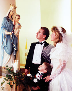 Craig and Linda Whitaker and Linda&rsquo;s&mdash;now the couple&rsquo;s&mdash;son Johnathan honor Mary during their wedding Mass at St. John the Evangelist Parish in Georgetown, Ky., on Dec. 8, 1990. (Submitted photo)