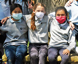 Quinn McGill, center, sits arm in arm with her friends and classmates Christina San, left, and Kaelynn De la Cruz on May 10 at St. Mark the Evangelist School in Indianapolis. Quinn, a fourth-grader at St. Mark, asked Indianapolis Mayor Joseph Hogsett to declare May 10 as &ldquo;Be a Friend Day,&rdquo; which the mayor did. (Photo by Sean Gallagher)