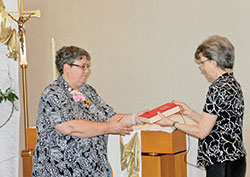 Benedictine Sister Julie Sewell ritually receives a copy of the Rule of St. Benedict from Benedictine Sister Jeanne Weber during a June 5 Mass at the chapel of Our Lady of Grace Monastery in Beech Grove in which Sister Julie was installed as the ninth prioress of the monastic community. Sister Jeanne is president of the Federation of St. Gertrude, an organization of 12 women&rsquo;s Benedictine communities in Canada and the United States. (Photo courtesy of Our Lady of Grace Monastery)