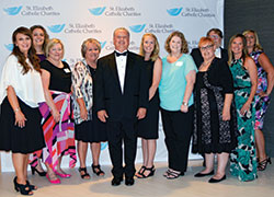 Mark Casper, executive director of St. Elizabeth Catholic Charities in New Albany, center, smiles with his staff during the organization&rsquo;s fundraising gala on June 24 in Louisville, Ky. (Photo by Natalie Hoefer)