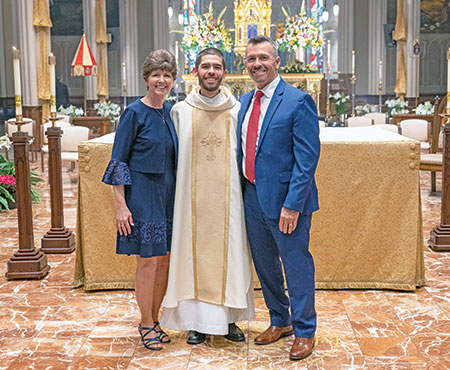 Holy Cross Father Geoffrey Mooney poses on April 10 in the Basilica of the Sacred Heart on the campus of the University of Notre Dame in northern Indiana with his parents, Sharon and Tom Mooney, after being ordained a priest for the Congregation of Holy Cross. Father Mooney grew up in Our Lady of Perpetual Help Parish in New Albany, where his parents continue to be members. (Submitted photo)