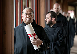 Benedictine Father Mateo Zamora waits on Aug. 15 to process into the Archabbey Church of Our Lady of Einsiedeln in St. Meinrad. The monk professed solemn vows that day as a member of Saint Meinrad Archabbey. He is holding a &ldquo;vow chart,&rdquo; which is a handwritten document that expresses a Benedictine monk&rsquo;s vows of obedience, fidelity to the monastic way of life and stability. (Photo courtesy of Saint Meinrad Archabbey)