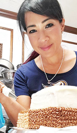Lani Pascual adds the finishing touches to one of her cake creations. She spreads God&rsquo;s love to others through the gift of baked goods. (Submitted photo)