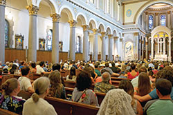 The congregation listens in St. Joan of Arc Church in Indianapolis as former pastor Guy Roberts delivers the homily for the parish&rsquo;s 100th anniversary celebration Mass on July 17. (Photo by Natalie Hoefer)