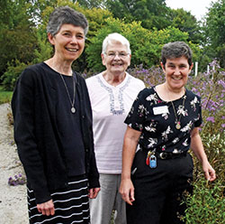 Sister Marie Therese Racine, left, Sister Angela Jarboe and Sister Sheila Marie Fitzpatrick, all members of the Benedictine Our Lady of Grace Monastery in Beech Grove, pose on Oct. 4 in their community&rsquo;s Peace and Nature Garden. (Photo by Sean Gallagher)