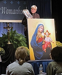 Society of Our Lady of the Holy Trinity Father James Blount holds a picture of St. Pio of Pietrelcina, popularly known as Padre Pio, during the Indiana Catholic Women&rsquo;s Conference at the Indiana Convention Center in Indianapolis on Sept. 25. (Photo by Sara Geer)
