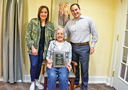 Family members of the late Joe Cathcart are all smiles as they pose with the plaque honoring the late beloved Catholic Youth Organization (CYO) football coach. Cathcart&rsquo;s daughter Kelly, left, his mother Joyce and his son David received the plaque from Bruce Scifres, executive director of the archdiocese&rsquo;s CYO. (Submitted photo)