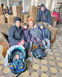 Dan Reichley, standing, poses with a family receiving twin bed kits from the Tri-County Good Samaritans St. Vincent de Paul Society in the Connersville Deanery. Reichley heads up the organization&rsquo;s furniture ministry. (Submitted photo)