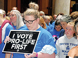 A pro-life advocate prays during a &ldquo;Love Them Both&rdquo; rally sponsored by Indiana Right to Life on July 26 at the Indiana Statehouse in Indianapolis. The rally took place while an Indiana Senate committee was preparing to vote on a bill that would ban most abortions in the state. (File photo by Sean Gallagher)