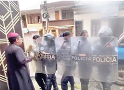 Bishop Rolando &Aacute;lvarez of Matagalpa, Nicaragua, is pictured in a screenshot from video at his residence in Matagalpa as riot police block the door. The police kept him and a group of priests, seminarians and lay Catholics under house arrest for about two weeks until Aug. 19 when the police seized them in a pre-dawn raid and took them in custody to Managua. 
(CNS screenshot/YouTube)