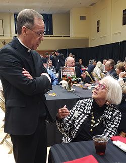 Archbishop Charles C. Thompson speaks with Christina Kellams at a reception in the Archbishop Edward T. O&rsquo;Meara Catholic Center in Indianapolis on Oct. 4. (Photo by Natalie Hoefer)