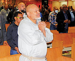 Franciscan Friars of the Renewal Father Agustino Torres prays in a pew before delivering a keynote address at the National Black Catholic Men&rsquo;s Conference at St. Rita Church in Indianapolis on Oct. 13. (Photo by Mike Krokos)