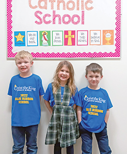 Walter Chandler, left, Gemma Karpinski and John Verspelt&nbsp;sport T-shirts showing their celebration of Christ the King School in Indianapolis being named a 2022 national Blue Ribbon School by the U.S. Department of Education. (Submitted photo)