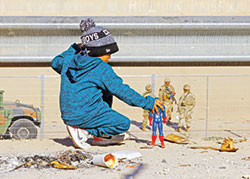 A migrant boy, who is traveling with his family to seek asylum in the United States, plays with a Captain America action figure along the&nbsp;border&nbsp;between Mexico and the United States in Ciudad Ju&aacute;rez, Mexico, on Dec. 27, 2022. Some families in the Archdiocese of Indianapolis have welcomed unaccompanied children at the border into their homes, serving as short-term foster parents for the children who hope to be reunited with their parents and other family members in the United States. (CNS photo/Jose Luis Gonzalez, Reuters)