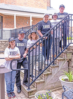 Six residents of the Village of Merici in Indianapolis&mdash;a Catholic-inspired place of hope and growth for adults with disabilities&mdash;showcase the hats and T-shirts that are part of a fundraising effort led by Cathedral High School grad and Cincinnati Bengals football player Ted Karras that has raised nearly $400,000 for the Village. The residents are Mary McClamroch, left, Jason Renie, Trese Mascari, Sarah Boyd, Angie Cain and Steve Mailloux.  (Submitted photo)