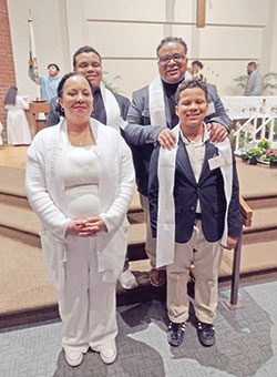 The Toliver family smiles in St. Lawrence Church in Indianapolis after being received into the full communion of the Church during the parish&rsquo;s Easter Vigil Mass on April 8. In the front row are June, left, and Justin. In the back row are Sidney, left, and Ramon. (Submitted photo)