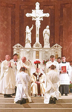 Archdiocesan priests ritually lay hands on transitional Deacons Jos&eacute; Neri, left, and Jack Wright while Archbishop Charles C. Thompson, center, looks on during a June 3 priesthood ordination Mass at SS. Peter and Paul Cathedral in Indianapolis. (Photo by Sean Gallagher)