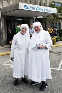 Sister Celestine Meade, left, and Sister Raymond Korterhof, both members of the Little Sisters of the Poor, smile outside the St. Augustine Home during an event marking the Little Sisters&rsquo; 150 years of service in central Indiana on Aug. 26. (Photo by Natalie Hoefer)