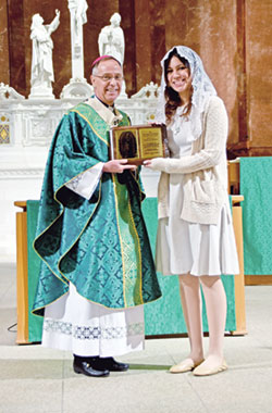 Sara Cabrera, a member of St. Thomas More Parish in Mooresville, receives the archdiocese&rsquo;s Our Lady of Guadalupe Pro-Life Youth Award from Archbishop Charles C. Thompson during the annual Respect Life Mass at SS. Peter and Paul Cathedral in Indianapolis on Oct. 1. (Photo by Natalie Hoefer)