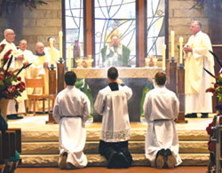 Archbishop Charles C. Thompson elevates the Eucharist during a 200th parish anniversary Mass at St. Mary-of-the-Knobs Church in Floyd County on Oct. 15. Concelebrating with him are Father Michael Hilderbrand, left, Father Stephen Banet, Conventual Franciscan Father John Elmer and Father Steven Schaftlein. Father William Marks, the parish&rsquo;s current pastor, is at right. (Photo by Natalie Hoefer)