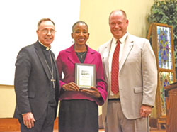 Archbishop Charles C. Thompson and Judge David Certo of the Marion County Superior Court pose on Oct. 2 with Angela Espada, executive director of the Indiana Catholic Conference during a dinner at the Archbishop Edward T. O&rsquo;Meara Catholic Center in Indianapolis following the annual Red Mass of the St. Thomas More Society of Central Indiana. Espada was honored with the society&rsquo;s Woman of All Seasons Award. (Photo by Sean Gallagher)